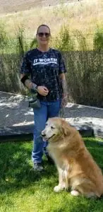 Woman standing with a golden retriever on grass